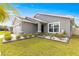 Single-story house with gray siding, two-car garage, and festive lights at 16178 Se 104Th Ter, Summerfield, FL 34491