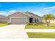 Single-story house with gray siding, two-car garage, and manicured lawn at 16178 Se 104Th Ter, Summerfield, FL 34491