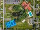 Aerial view of community features including clubhouse, pool, tennis courts, and pond at 17925 Se 100Th Ter, Summerfield, FL 34491