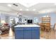 Modern kitchen island with blue cabinets and view into living area at 17925 Se 100Th Ter, Summerfield, FL 34491