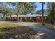Brick house with metal roof, long driveway, and trees at 22740 County Road 44A, Eustis, FL 32736