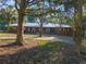 Brick ranch home with metal roof and long driveway, framed by trees at 22740 County Road 44A, Eustis, FL 32736