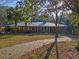 Brick ranch home with metal roof, long driveway, and mature landscaping at 22740 County Road 44A, Eustis, FL 32736