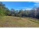 Large parcel of land with mature trees and a fenced area at 22740 County Road 44A, Eustis, FL 32736