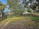 Large backyard with a wooden fence and mature trees at 235 Hyde Park Ave, Eustis, FL 32726