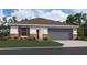 One-story home with gray garage door and brown roof at 2986 Supermarine Rd, Tavares, FL 32778