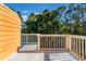 Private deck with white railing, overlooking lush trees at 3141 Britannia Blvd # D, Kissimmee, FL 34747