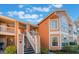 Exterior view of a two-story building with orange siding and a staircase at 3141 Britannia Blvd # D, Kissimmee, FL 34747