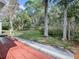 Landscaped backyard with a wooded backdrop at 32314 Oak Park Dr, Leesburg, FL 34748