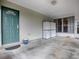 Covered porch with teal door and storage at 32314 Oak Park Dr, Leesburg, FL 34748
