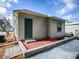 Tan house with a green door and small patio at 32314 Oak Park Dr, Leesburg, FL 34748