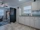 White kitchen with sink, cabinets, and view into living area at 32314 Oak Park Dr, Leesburg, FL 34748