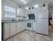 White kitchen boasts ample cabinetry, a stove, microwave, and refrigerator at 32314 Oak Park Dr, Leesburg, FL 34748