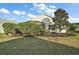 Landscaped backyard with manicured lawn and screen patio at 3810 Cosmos Way, The Villages, FL 32163