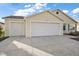 Two-car garage with light beige vinyl siding and landscaping at 3810 Cosmos Way, The Villages, FL 32163