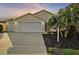 Inviting exterior with a two-car garage and landscaped yard at 3810 Cosmos Way, The Villages, FL 32163