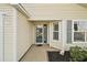 Front entry with a glass door and decorative landscaping at 3810 Cosmos Way, The Villages, FL 32163