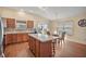 Kitchen features an island, stainless steel appliances, and wood cabinets at 3810 Cosmos Way, The Villages, FL 32163