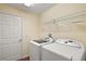 Laundry room with washer, dryer, and storage shelves at 3810 Cosmos Way, The Villages, FL 32163