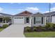 Two-car garage and gray siding with red accents at 5820 Bamboo Ave, The Villages, FL 32163