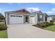 Two-car garage with gray siding and red accents at 5820 Bamboo Ave, The Villages, FL 32163