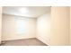 Small bedroom with window, blinds and neutral colored carpet at 716 Se 64Th Ter, Ocala, FL 34472