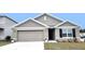 One-story house with gray siding, two-car garage, and landscaping at 716 Se 64Th Ter, Ocala, FL 34472
