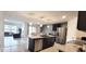 Open kitchen features an island with seating, stainless steel appliances, and a view to the living room at 716 Se 64Th Ter, Ocala, FL 34472