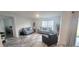 Bright living room with two sofas, a chair, and a view into a bedroom at 716 Se 64Th Ter, Ocala, FL 34472