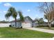 One-story house with a gray exterior, palm trees, and a white fence at 76 Zachary Wade St, Winter Garden, FL 34787