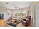 Relaxing living room with a sofa, recliner, and large windows offering natural light at 821 Ramos Dr, The Villages, FL 32159