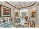 Bright dining room with a glass-top table, chandelier, and views of the living room at 9029 Mossy Oak Ln, Clermont, FL 34711