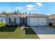 One-story home with gray siding, white garage door, and landscaped lawn at 1109 Catskill Dr, Haines City, FL 33844