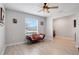 Living room with a red couch, ceiling fan, and large window at 136 White Horse Way, Groveland, FL 34736