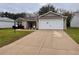 House exterior featuring a two-car garage and driveway at 1605 Alhambra Way, The Villages, FL 32162