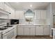 Clean white kitchen with stainless steel appliances and a tile backsplash at 17640 Se 81St Timberwood Ter, The Villages, FL 32162