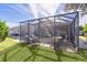 Screened patio and grassy backyard with sunny day at 2243 Montbrook Pl, The Villages, FL 32162