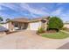 Single-story home with a two-car garage and landscaped yard at 2243 Montbrook Pl, The Villages, FL 32162