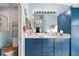 Double vanity bathroom with a modern look and blue cabinets at 27437 Desert Rose Ct, Leesburg, FL 34748