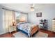 Cozy bedroom with wood floors, window, ceiling fan and neutral decor at 27437 Desert Rose Ct, Leesburg, FL 34748