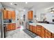 Bright kitchen featuring wood cabinets, a large island, and stainless steel appliances at 27437 Desert Rose Ct, Leesburg, FL 34748