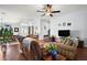 Spacious living room with hardwood floors, leather furniture, and a ceiling fan at 27437 Desert Rose Ct, Leesburg, FL 34748