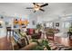 Open living space with hardwood floors, a large window, and access to the kitchen at 27437 Desert Rose Ct, Leesburg, FL 34748