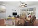 Living area with brown leather couches, wood floors, and large window at 27437 Desert Rose Ct, Leesburg, FL 34748