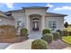 Elegant home exterior with a covered entryway, manicured landscaping, and a neutral color palette at 2850 Cedar Grove Loop, The Villages, FL 32163