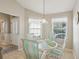 Bright breakfast nook with glass-top table and striped chairs near entry at 2876 Manor Downs, The Villages, FL 32162