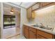 Kitchen with wood cabinets, stainless steel sink, and view into adjoining dining area at 636 Mount Homer Rd # 636, Eustis, FL 32726