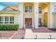Inviting front entrance of two-story house with red double doors and landscaping at 6607 Crestmont Glen, Windermere, FL 34786