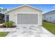 Attached garage with screen door and decorative stone driveway at 869 Aiken Ave, The Villages, FL 32162