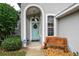 Front entry with light blue door, arched entryway, and wood bench at 87 Twin Lake Cir, Umatilla, FL 32784